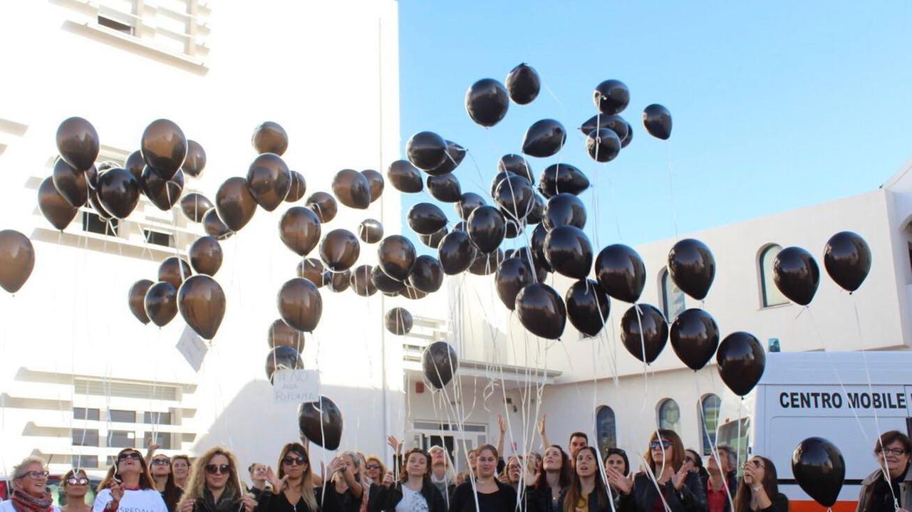 In aria cento palloncini neri per dire no alla riforma sanitaria