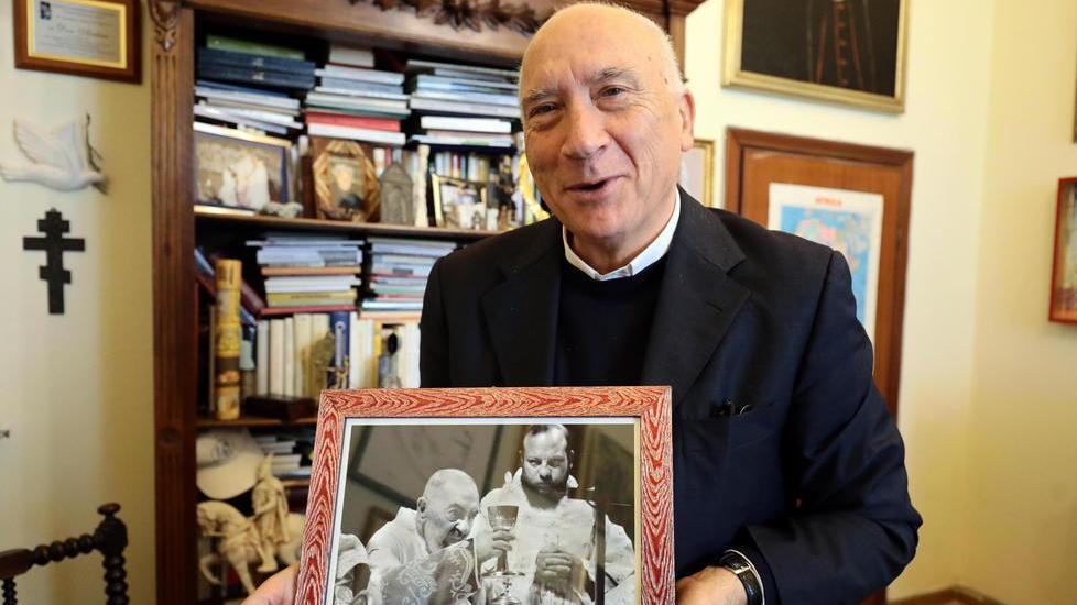 Don Andrea Cristiani mostra una foto di Padre Pio (Agenzia Carlo Sestini)
