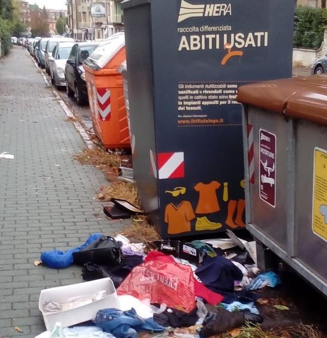 Abiti usati buttati fuori dai cassonetti per strada 