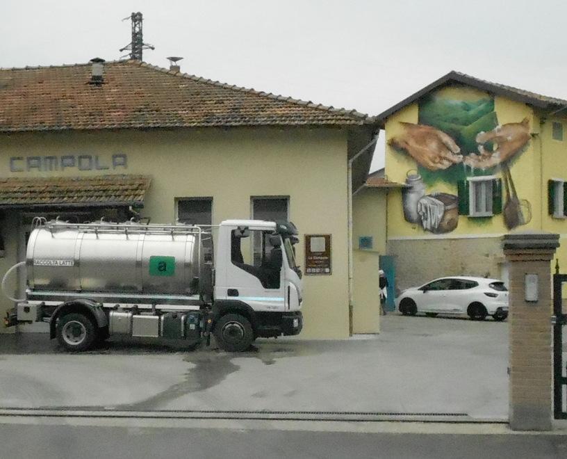 Le colline e le mani del casaro in un murales alla latteria 