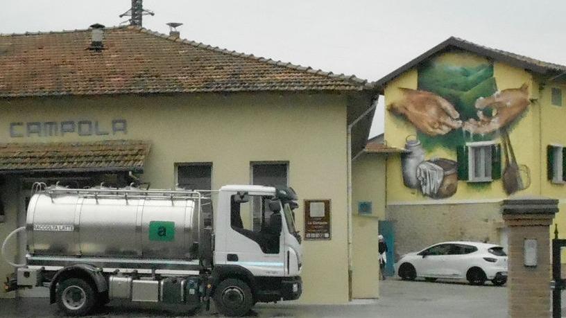 Le colline e le mani del casaro in un murales alla latteria