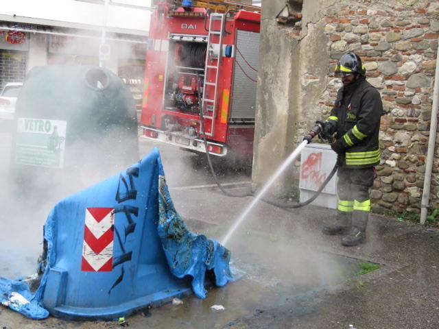 Un vigile del fuoco spegne l'incendio di un cassonetto (foto d'archivio)