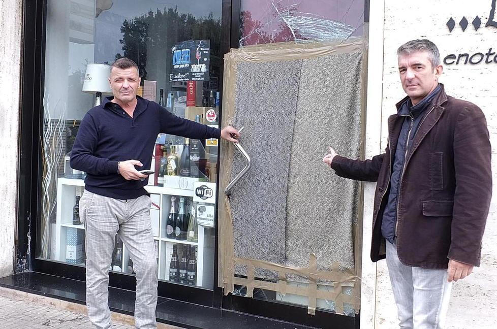 Alessandro Mainardi (a destra) indica la vetrata spaccata del locale (foto Renzullo/Muzzi)