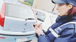 Una ausiliaria del traffico mentre fa una multa