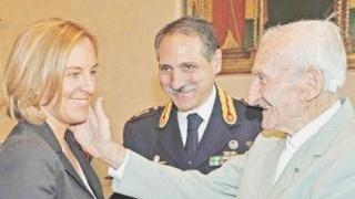 Fratoni saluta un poliziotto in pensione. A fianco il gruppo delle medaglie di bronzo. Sotto Fabrizio Giannini
