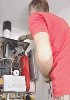 Un tecnico al lavoro per la revisione di una caldaia