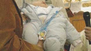 Il battesimo di una bambina con l’aspersione di acqua benedetta