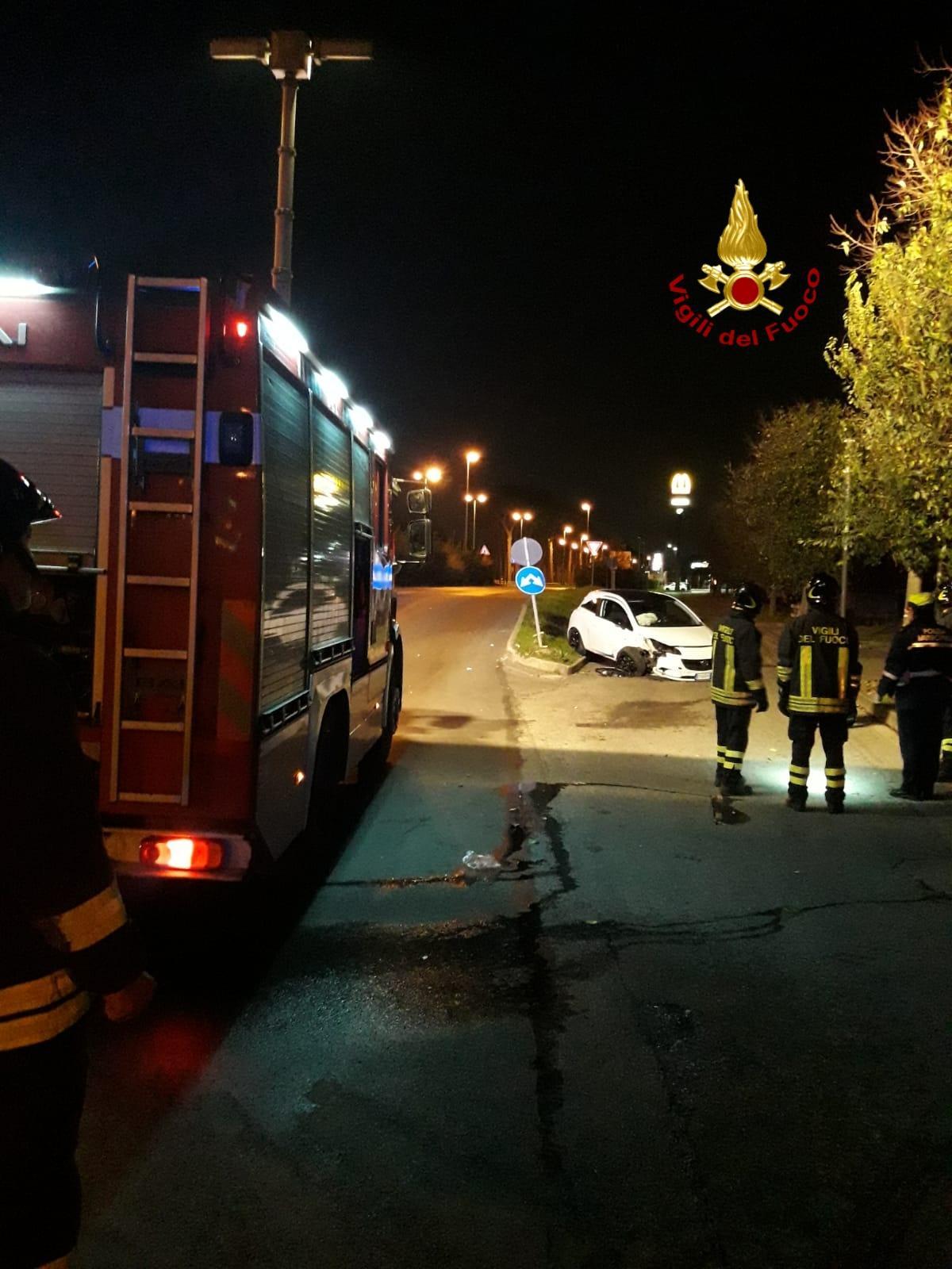 L'intervento dei vigili del fuoco, sullo sfondo l'auto del ventottenne fuori strada