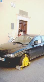 Un’auto con la ruota bloccata dalle ganasce