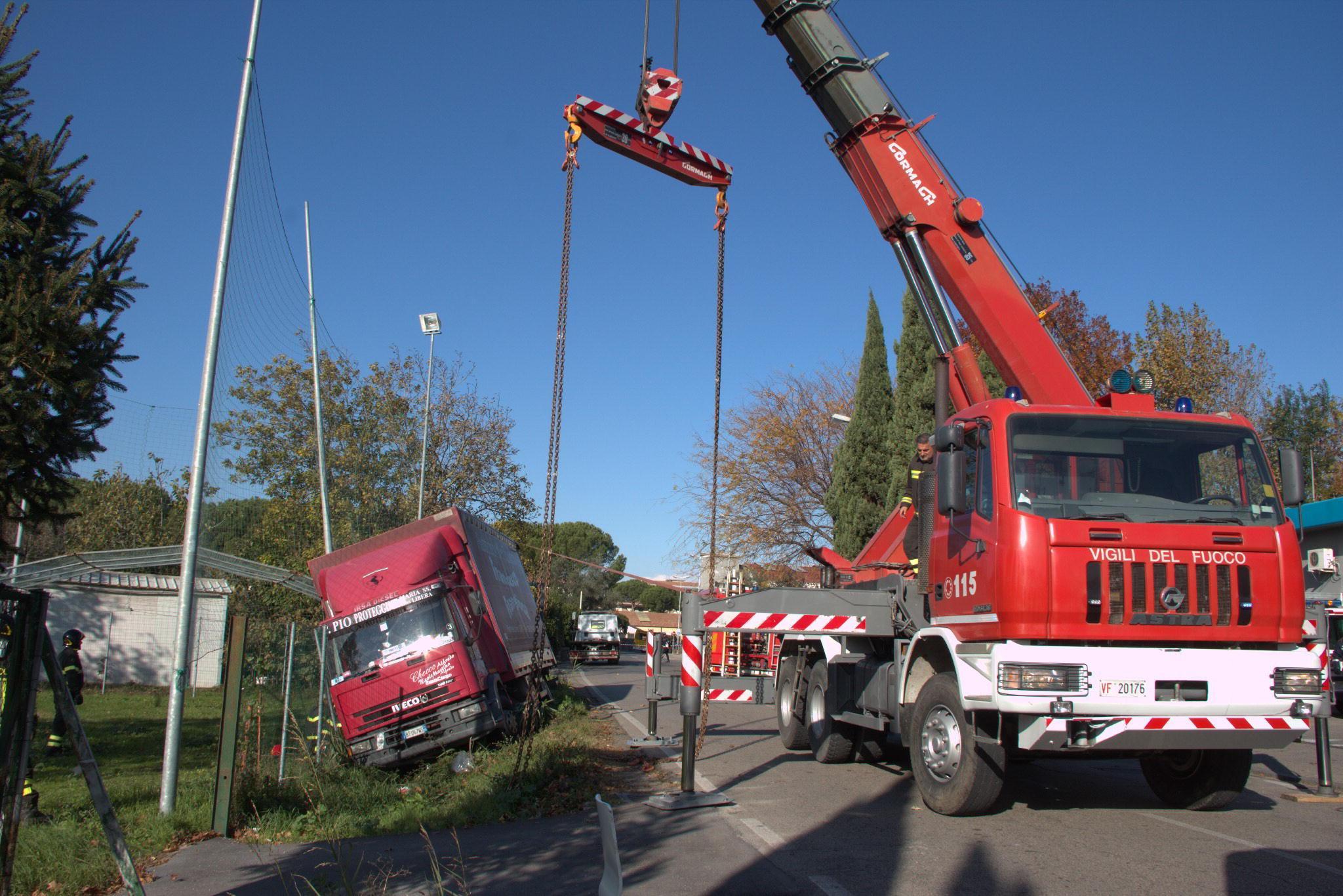 L'intervento dell'autogru dei vigili del fuoco in via Ferrucci a Mezzana per il camion uscito di fuori strada