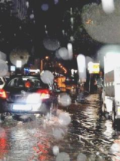 Due immagini dell’acquazzone di ieri sera: sopra, traffico in tilt in via Fratelli Rosselli, a destra si cerca di liberare una fogna
