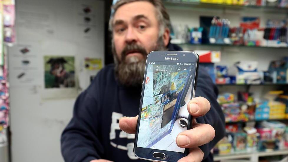 Giorgio Giorgi mostra sullo smartphone la vetrina della sua edicola sfondata dai ladri (Foto Agenzia Carlo Sestini)