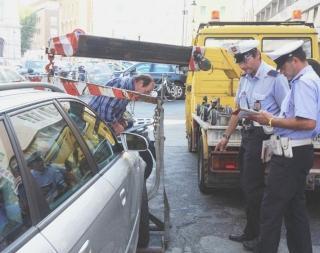 A sinistra la rimozione di un’auto in via Garibaldi e sopra uno scooter rimosso nei pressi di piazza Benamozegh. A destra il volantino che da oggi sarà lasciato sulle auto bloccate con le ganasce perché in sosta vietata nella Ztl: in evidenza è scritto “Attenzione veicolo bloccato, non mettere in moto”