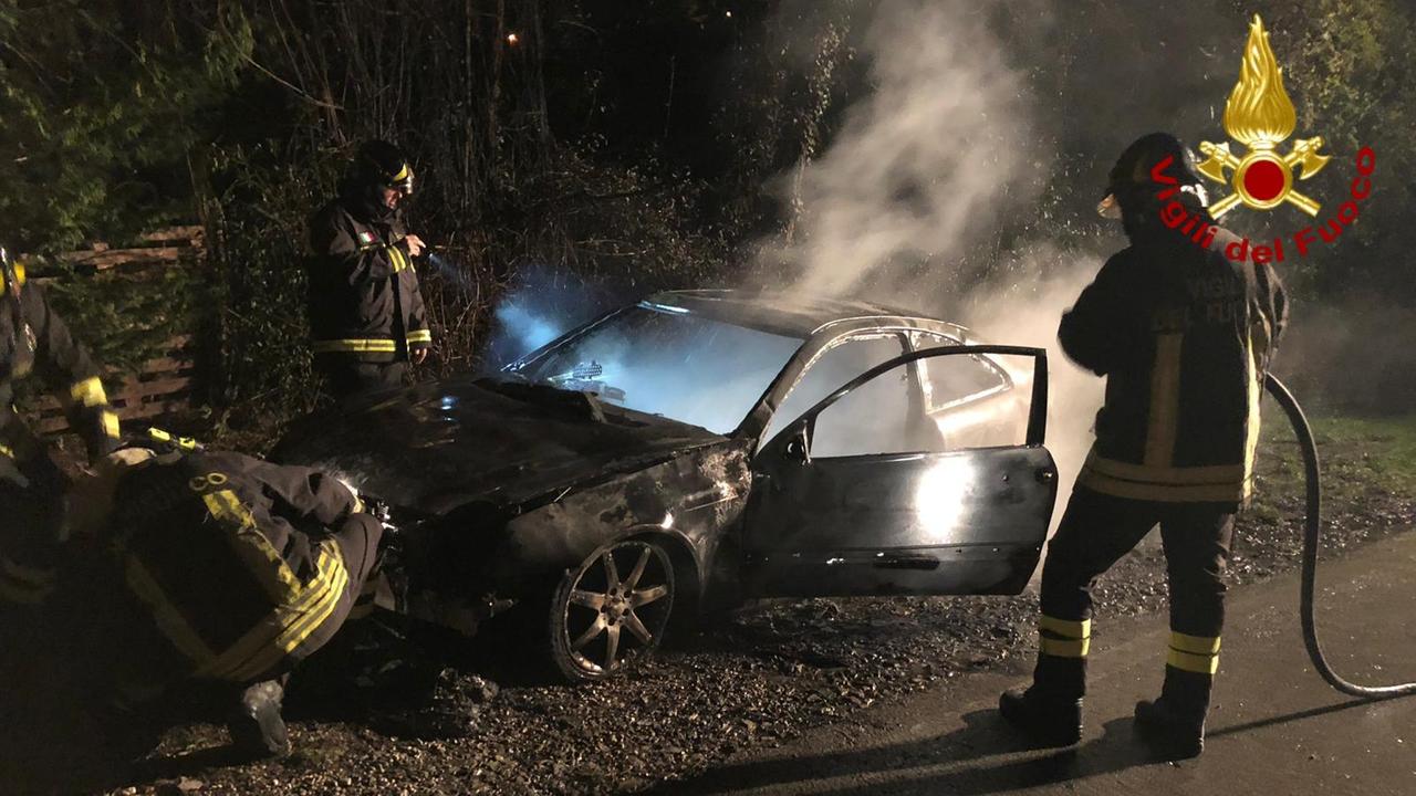 I vigili del fuoco all'opera sull'auto incendiata
