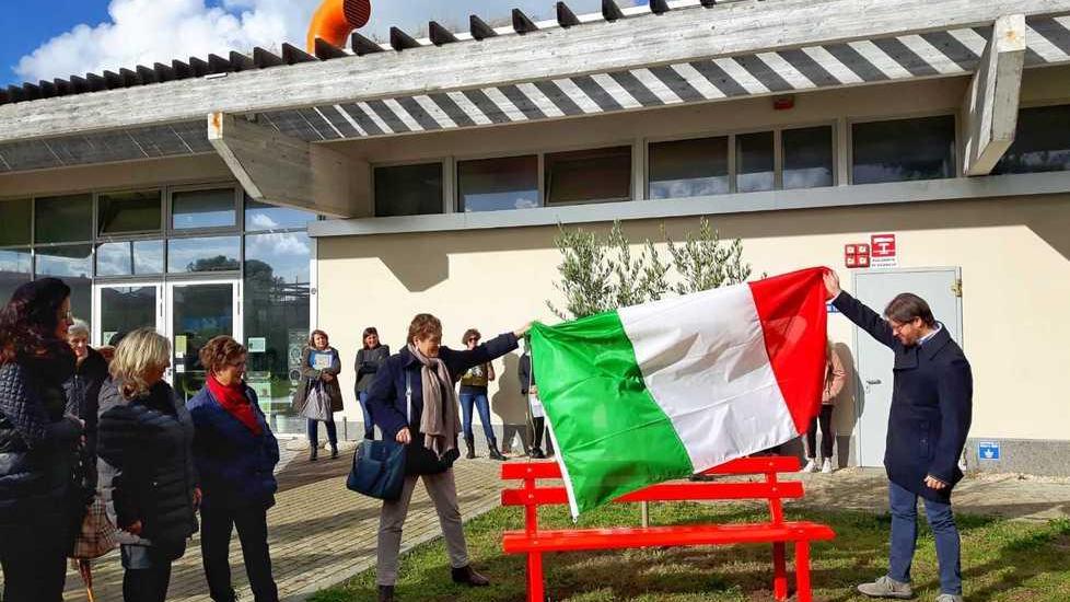 Una panchina rossa davanti al centro “Le Creste”