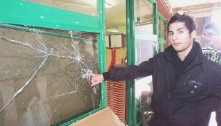 Uno studente mostra il vetro rotto dai giovani che hanno tentato l’assalto all’Enriques