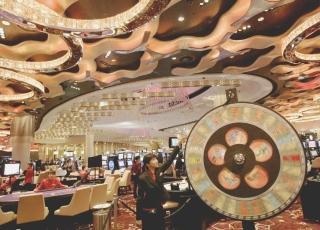 Una avveniristica sala da gioco a Macau dove migliaia di giocatori si alternano a tavoli verdi e slot machine