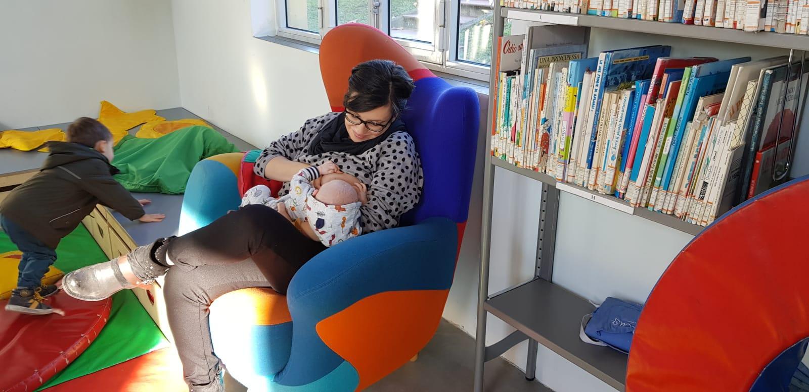 Una mamma allatta il bimbo al baby pit stop alla biblioteca Della Fonte