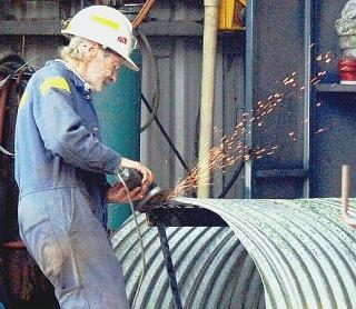 Sopra, un operaio metalmeccanico in officina A destra, un colloquio di lavoro in un’agenzia