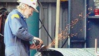 Sopra, un operaio metalmeccanico in officina A destra, un colloquio di lavoro in un’agenzia
