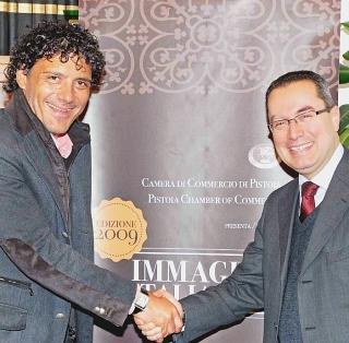 Una riunione nella sala consiglio. In alto stretta di mano tra Incerpi (a sin.) e Morandi