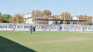 Il sindaco di Cecina Stefano Benedetti e, a fianco lo striscione di contestazione