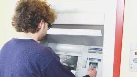 Un cliente mentre preleva contanti a un bancomat
