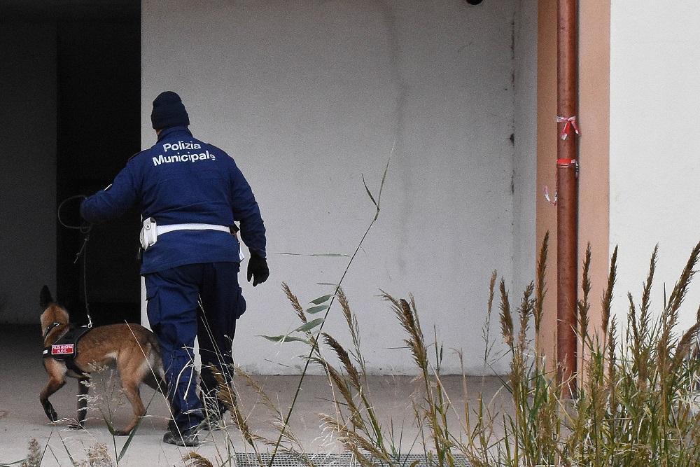 Un agente della Municipale entra in uno degli appartamenti occupati con il cane antidroga (foto agenzia Bf)