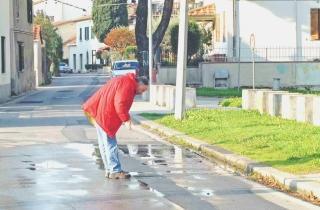 Un residente osserva la pozzanghera che si è formata davanti alla scuola media