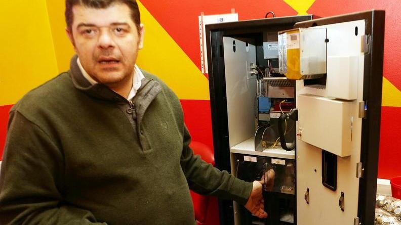 Manuele Mancini, il dipendente del Bar Valerio rapinato, davanti alla macchinetta scassinata (Foto Nucci)