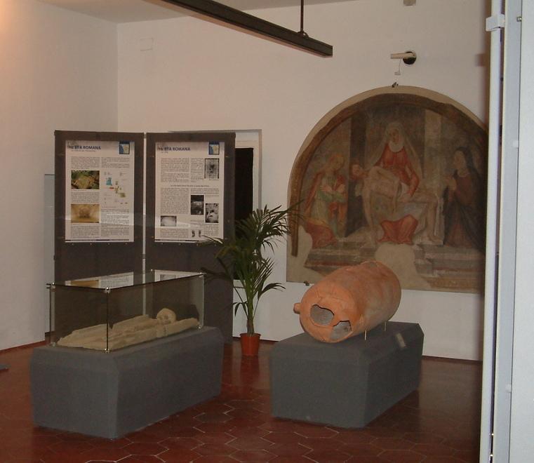 Sullo sfondo l'affresco della Pietà in una sala del museo archeologico