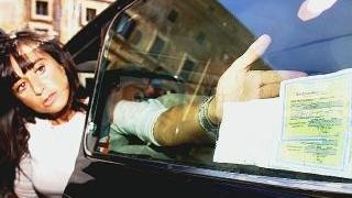Una automobilista applica bene in vista il tagliando della Rc Auto