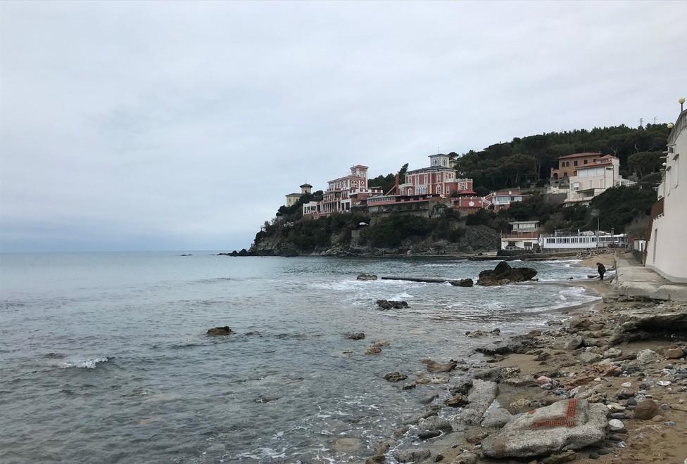 Una spiaggia erosa alla baia del Quercetano, con sassi e cemento che hanno invaso la costa
