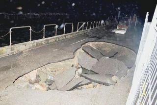 L’enorme buca che si è aperta ieri davanti al bar del porto Sullo sfondo le fioriere rimaste sulla strada: un paio sono finite in mare