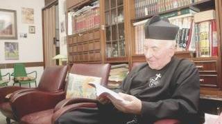 Padre Alfredo Pallotta mentre sfoglia uno dei suoi libri