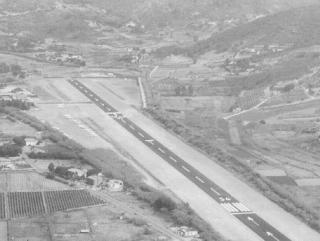 Passeggeri in aeroporto, accanto la pista d’atterraggio
