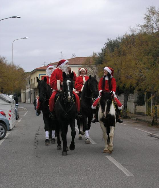 Babbo Natale a cavallo e auto fuori dal centro