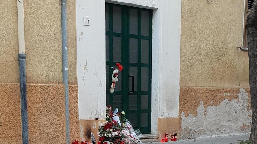 Omaggi floreali e lumini davanti alla casa dove viveva Michela Fiori