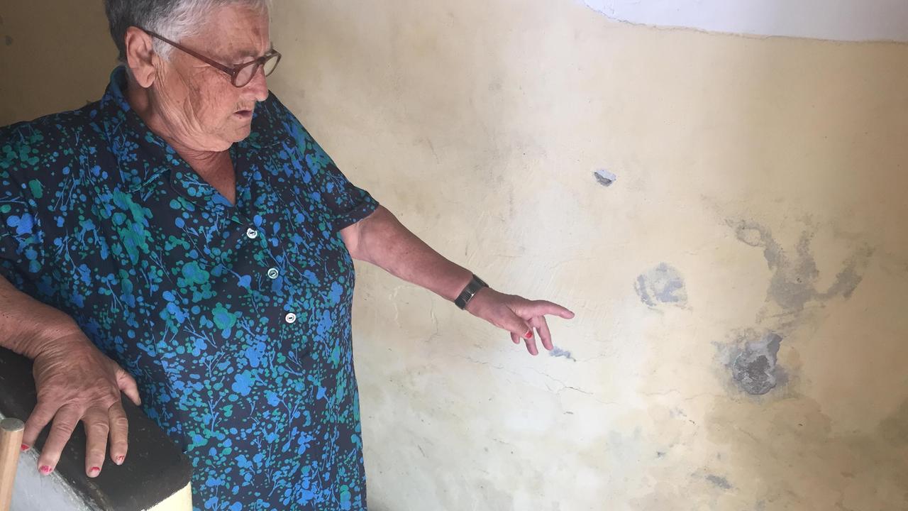 Un'inquilina mostra le macchie di umidità in casa