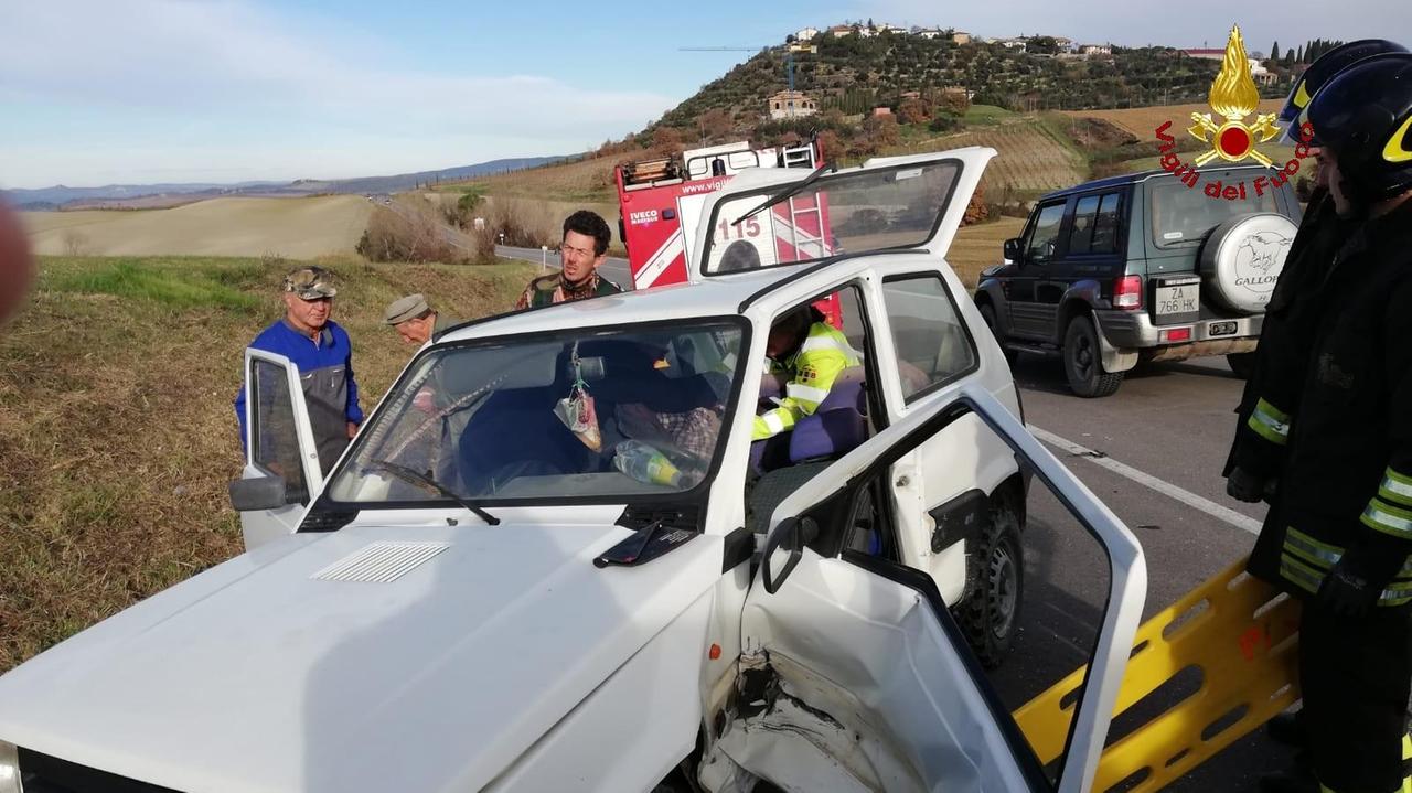 Una delle auto coinvolte nell'incidente e un gruppo di soccorritori