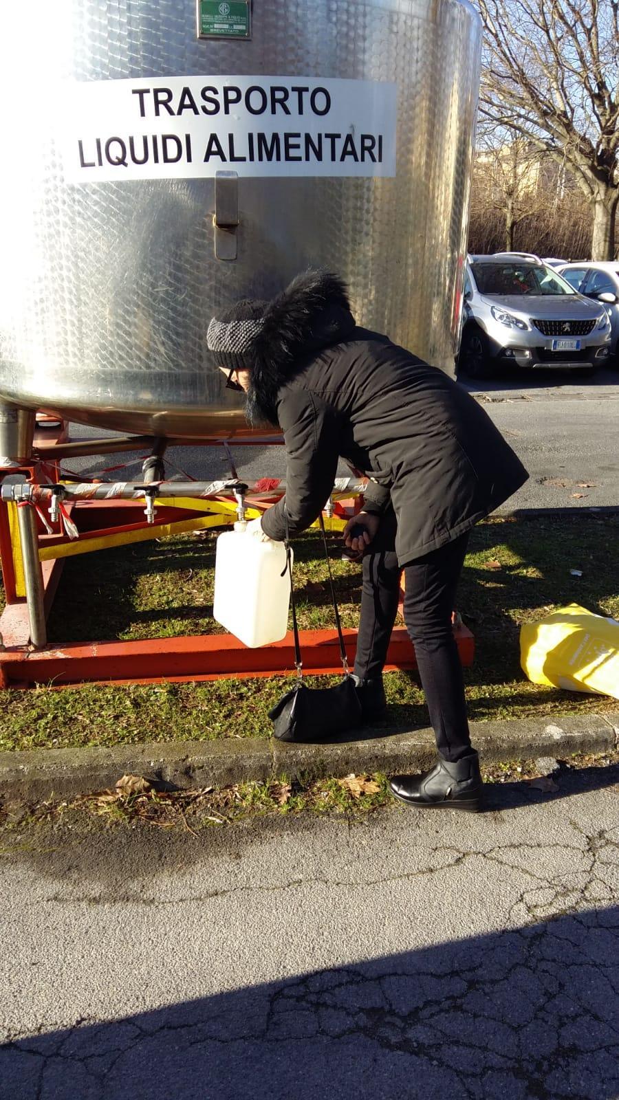 I cittadini in piazza della Stazione si riforniscono d'acqua con delle taniche 