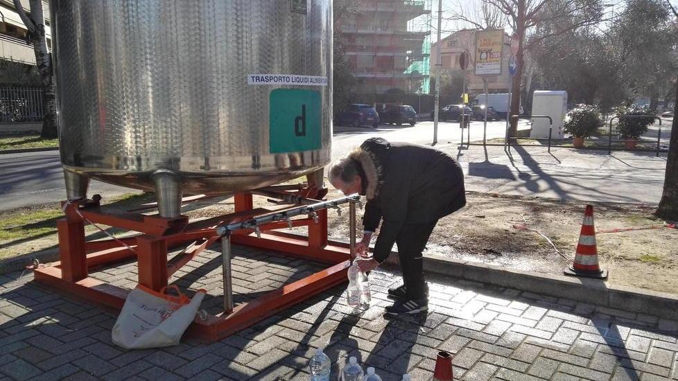 Un residente intento a riempire bottiglie d’acqua dalla botte collocata in via Capponi alla Pietà