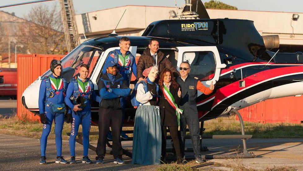 La vecchietta scende dal cielo e dalla torre grazie ai paracadutisti e ai vigili del fuoco