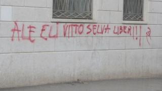 In alto, la scritta contro La Russa, sopra, quella inneggiante a Bobby Sands; a sinistra, quella per i 4 arrestati di Pistoia