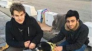 I due studenti con il cane che era caduto nelle acque del porto dopo il suo salvataggio
