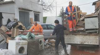 Alcuni residenti recuperano nel fango ciò che resta delle case