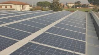 Pale eoliche in mare e, a sinistra, un impianto fotovoltaico