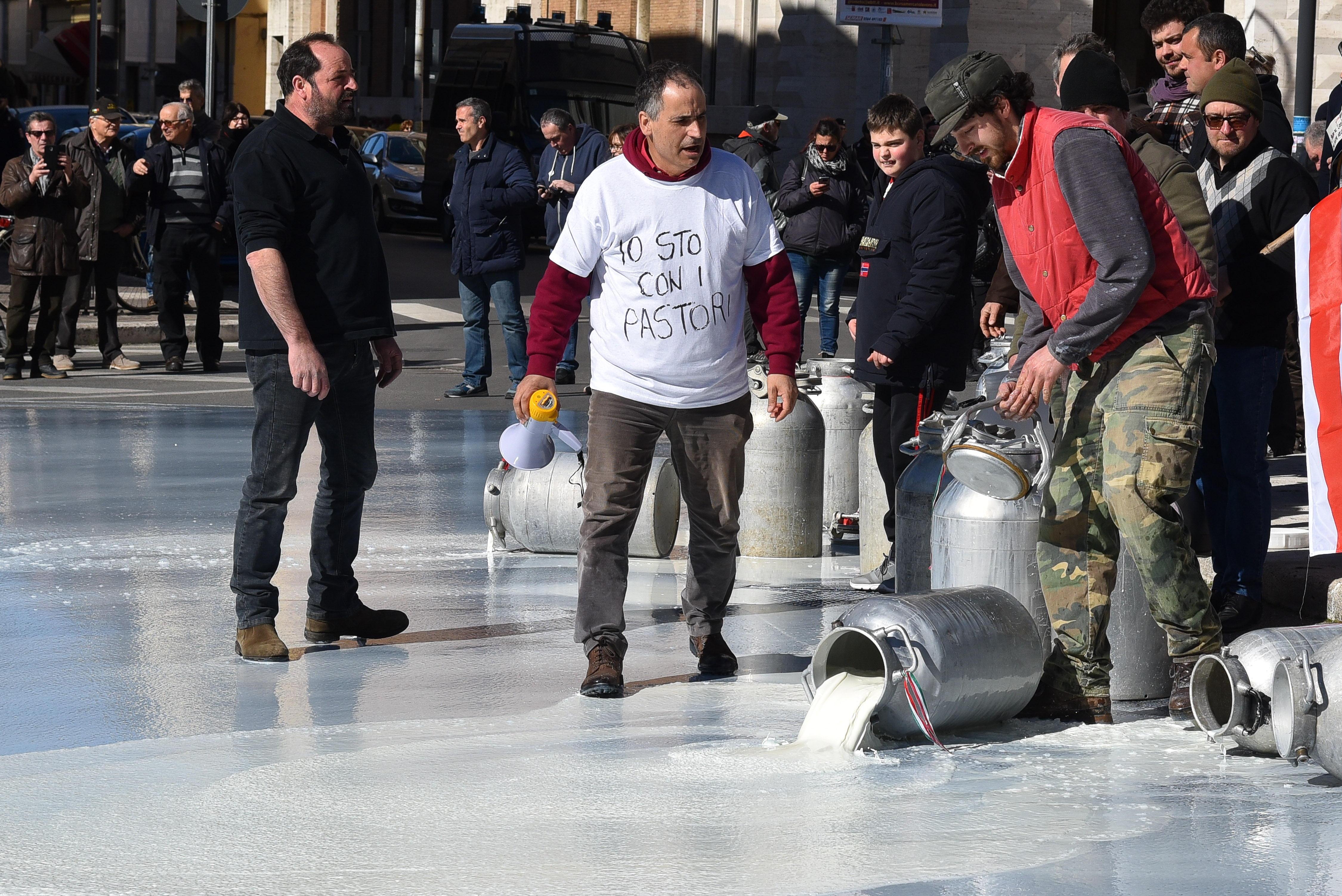I bidoni di latte rovesciati dagli allevatori in piazza della vasca (Foto Agenzia Bf)