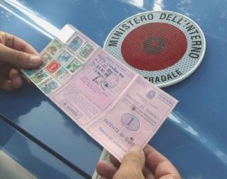 Un agente della Polstrada controlla una patente di guida