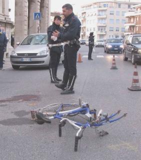 La bicicletta a terra dopo l’incidente, sulla destra l’auto investitrice
